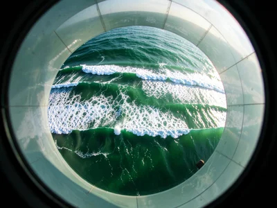 Aerial view of wave sets approaching shore — parallel lines of swells with break