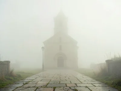 Worn pavement of stone slabs leading toward a fogged-in chapel, the chapel itsel