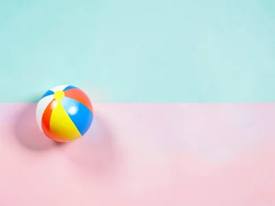 Wide pastel paper sweep with only one beach ball positioned in the lower-left th