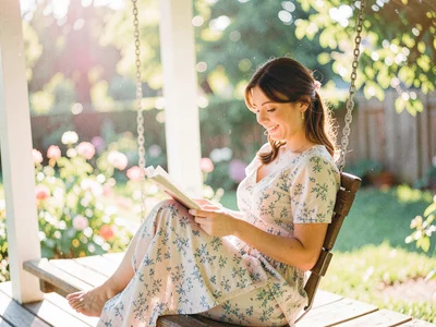 A woman reading on a porch swing in summer afternoon