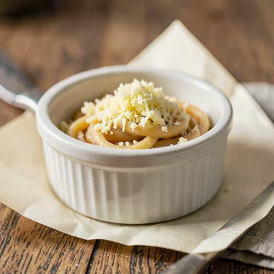 small porcelain ramekin of cured-egg-yolk grated like cheese over a tiny mound o