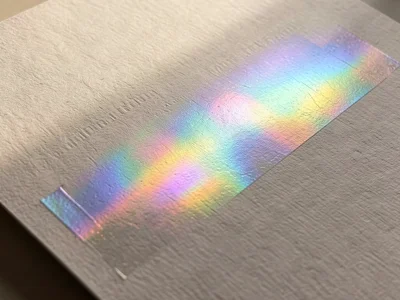 Holographic foil sheet, rainbow diffraction pattern shifting across the surface 