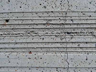 Board-formed concrete wall surface, horizontal wood grain impressions from plywo