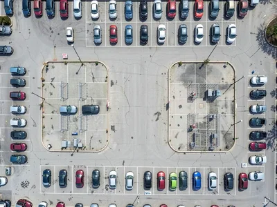 Walmart parking lot, cars arranged in near-perfect grid with cart corral islands