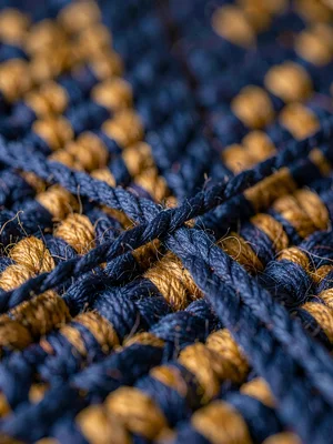 Single thread of indigo-deep wool stretched taut shows fiber twist and warm halo