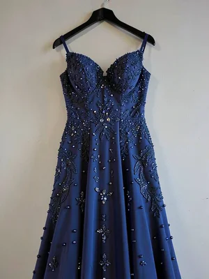 Wedding dress preserved in deep blue, every bead and stitch visible, hanging alo