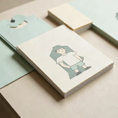 Papercraft hero of layered paper album sleeves stacked at angles across a paper