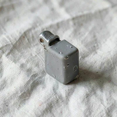 Flicked putty-grey lighter with a slumped flint guard and fingernail dents along