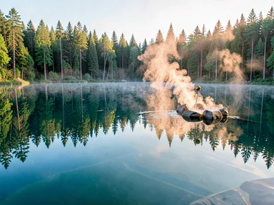 Finnish lake mirror, dead-calm reflection, steam rising from sauna stones as wat
