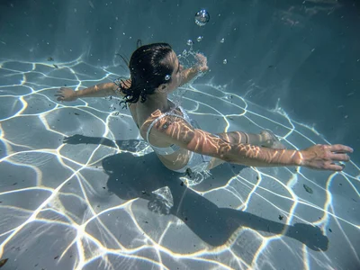 Swimmer cutting through caustic light