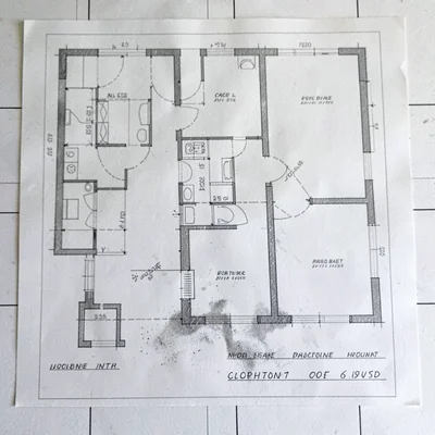 Ghosted overlay of two stacked floor-plan drawings, the underlying as-built shif