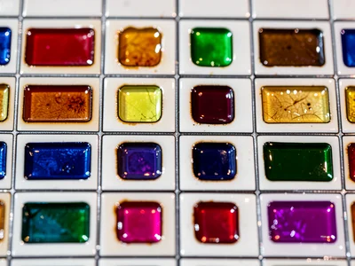 Enamel palette — small fired test samples in rows by color on white ceramic tile
