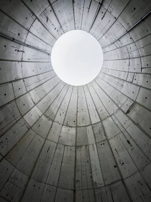 Concrete cooling tower interior shot looking up, ribs converging like a vast inv