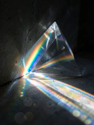 Prismatic light fanning through a crack in a dark wall, single beam splitting in