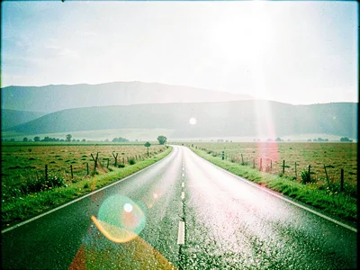 Long flat county road extending forward into a horizon doubled by a faint duplic