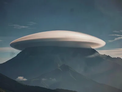 Single lenticular cloud forming over invisible mountain