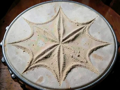 Fine sand on drum head showing six-pointed star pattern at resonance