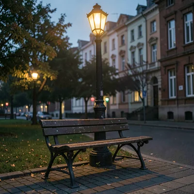 Atmospheric photo of a single park bench under a streetlamp at twilight