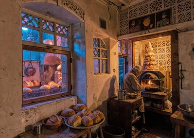 Colored light through qamariya windows in Sana'a, Yemen, baker pulling bread fro
