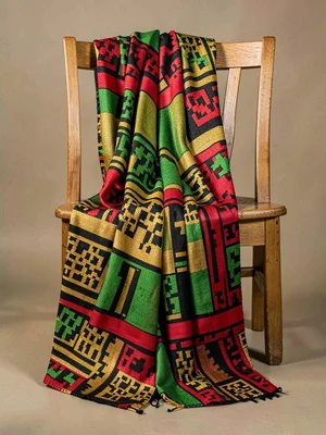 Ceremonial kente cloth draped over a wooden chair — pattern cascading in folds