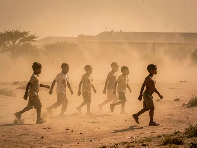 Children playing as moving shadows in dust atmosphere
