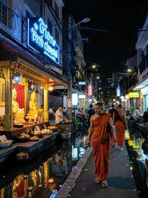 Monk passing blue neon at night