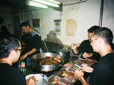 Fluorescent kebab shop at 3am, exhausted worker behind counter, drunk customer t