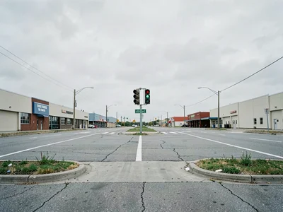 Traffic signal intersection, no vehicles, flat commercial strip in all direction