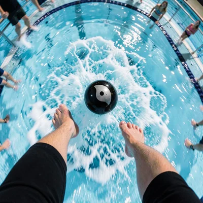 Cannonball entry from jumper's POV, pool surface rushing up warped, legs and fee