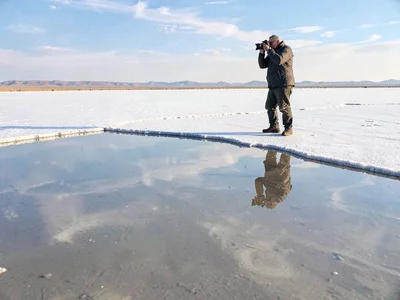 Photographer capturing reflection becoming part of it