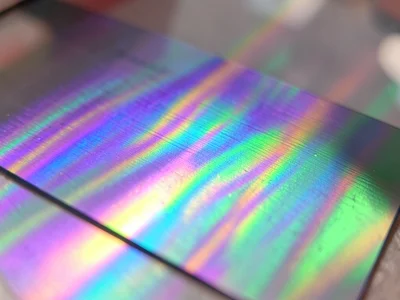 Metallic interference coating on glass, viewing angle creating broad purple-to-g