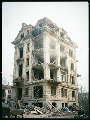 An old building facade double-exposed with its demolition, the past and future o