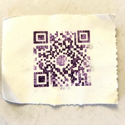 A QR code printed on thermal paper, partially faded so it can no longer be scann