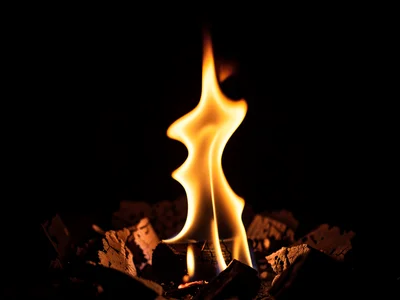 Single flame tip dancing in darkness