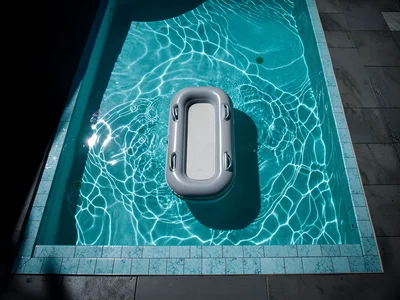 Overhead view of swimming pool with single float, turquoise water, tile edge
