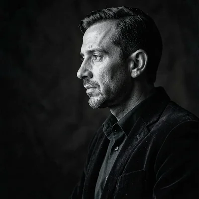 Charcoal portrait of a debater in profile, mid-line, deep velvet darks