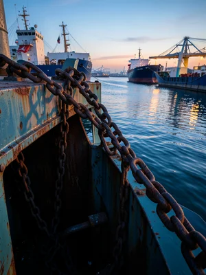 An anchor chain running out: each massive link, the chain locker below, rust and