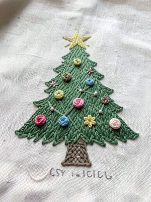 Embroidered Christmas tree on green fabric, ornaments as french knots