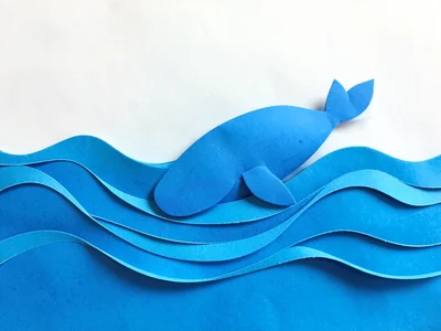Paper craft ocean waves in layers, whale made of blue paper breaching surface