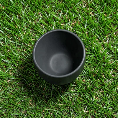 matte ceramic plant pot with no plant centred top-down on a saturated grass-gree