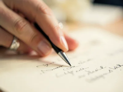 Pen tip touching signature line on divorce papers, hand a soft blur, wedding rin