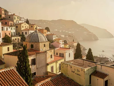 Rolling rooftop sea broken by a stone dome and a few cypresses, dry warm light f