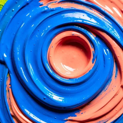 Swirling liquid paint in electric blue and coral, high-speed macro photography