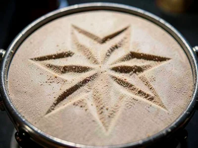 Fine sand on drum head showing six-pointed star pattern at resonance