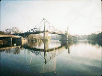 A bridge double-exposed with its reflection, the real and reflected versions sli