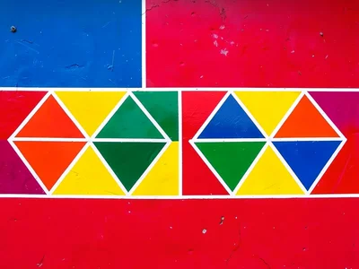 Detail of a painted wall — single horizontal band of bold color blocks and trian