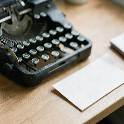 Macro of a typewriter ribbon and a folded paper note on a desk