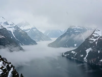 Snow on ridges visible through clearing mist