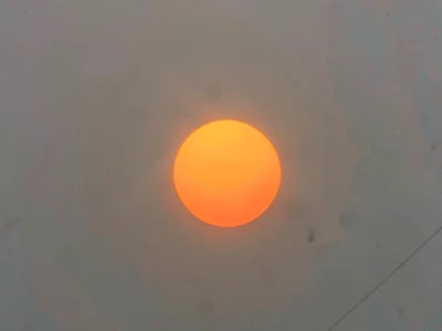 Sun as orange disk through haze