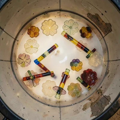 Kiln interior with millefiori fusing — faint glow, flower slices visible on shel